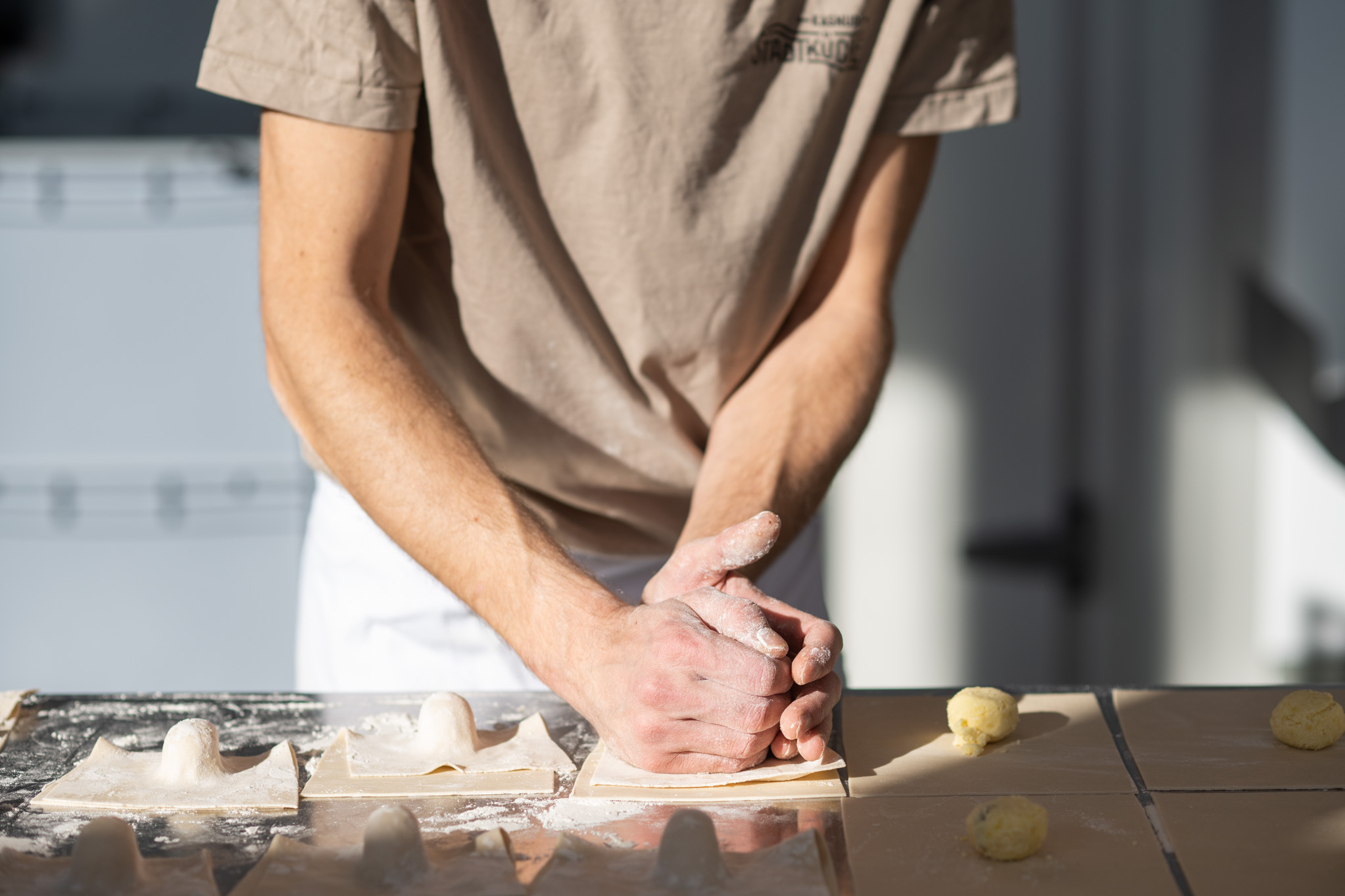 Hände beim Formen von frischem Teig